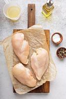 rå kyckling bröst på en skärande styrelse foto