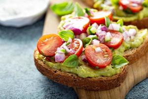 färsk guacamole och tomat smörgås spridning foto