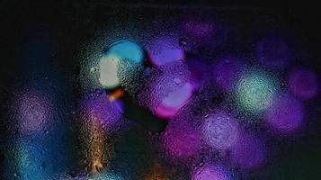 lila neon suddig lampor genom glas fönster med regndroppar på den i karachi pakistan 2022 foto