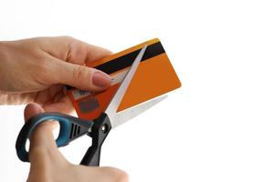 kvinna skärande henne kreditera kort med en sax foto