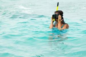 kvinna i de hav under snorkling i blå vatten foto