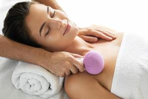 kvinna är njuter asiatisk massage terapi med ört- komprimera foto
