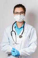 kvinna läkare med en stetoskop på grå bakgrund foto