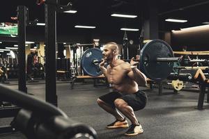 kroppsbyggare under hans träna med en skivstång i de Gym foto