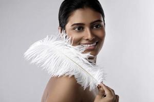 ung och sensuell indisk kvinna med en mjuk struts fjäder foto