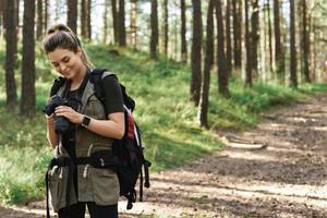 vandrare använder sig av modern mirror kamera i grön skog foto