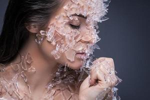 kvinna ansikte täckt med en massa små bitar av glas eller is foto