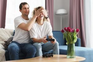 ung Lycklig par spelar video spel trösta foto