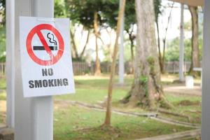 Nej rök tecken på en träd på offentlig parkera. foto