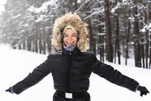 ung och glad kvinna njuter gående under skön vinter- dag foto