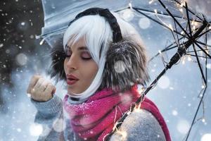 ung kvinna gående under transparent paraply på snöig vinter- dag foto