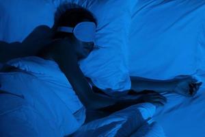 kvinna sovande med en sömn mask på henne ögon foto