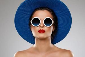 skön kvinna bär blå hatt och solglasögon är redo för semester foto