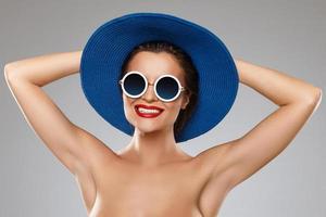 skön kvinna bär blå hatt och solglasögon är redo för semester foto