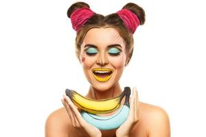 skön modell med kreativ pop- konst smink innehav bananer foto
