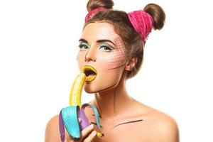 skön modell med kreativ pop- konst smink innehav banan foto