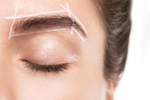 kvinna ansikte under professionell ögonbryn kartläggning procedur innan permanent smink foto