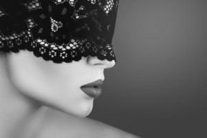 ung skön kvinna bär svart spets blind- foto