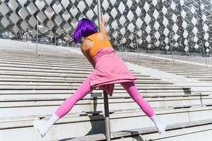 sorglös kvinna dansare bär färgrik sportkläder har roligt på de Pol foto