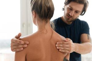 massör man håller på med tillbaka massage för hans kvinna klient foto