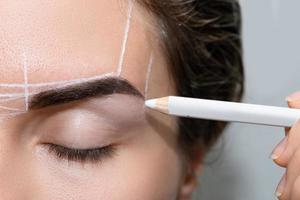 kvinna under professionell ögonbryn kartläggning procedur foto