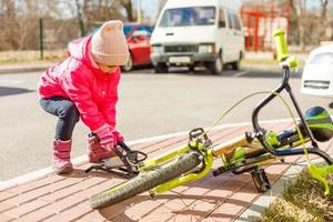 en liten flicka pumps upp en cykel däck foto