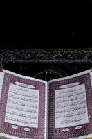 al-koranen som är ovan de bön matta med en svart bakgrund foto