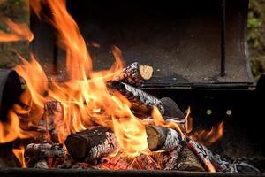 brinnande ved i de utegrill, de begrepp av utomhus- rekreation foto