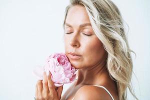 skönhet porträtt av blond hår ung kvinna med rosa pion i hand isolerat på vit bakgrund foto