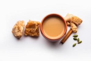 jaggery te eller gur ki chai med Ingredienser tycka om gud, ingefära eller adrak, grön kardemumma och kanel foto