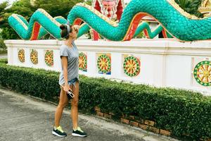 ung kvinna turist är sightseeing buddist tempel i thailand. foto