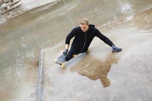 ung handikappade kille med en longboard i en skatepark foto