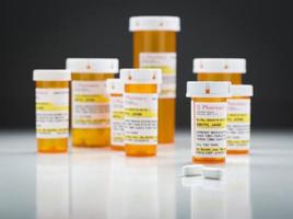 medicin flaskor och piller på reflekterande yta med grå bakgrund foto