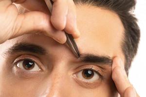 manlig ögon och pincett för ögonbryn form korrektion foto