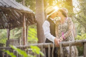 1920 klädd romantisk par kissing på trä- bro foto