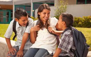 ung latinamerikan studerande barn bär ryggsäckar på skola campus foto