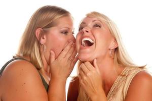 två blond kvinna viskande hemligheter foto
