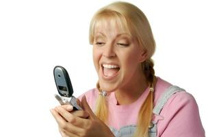 Lycklig flicka textning med cell telefon foto