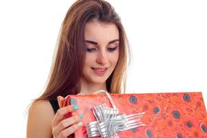 ung flicka innehav en röd presentpapper och leende isolerat på vit bakgrund foto