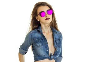 porträtt av en ung flicka i en ljus sommar speglad glasögon och jeans skjorta foto