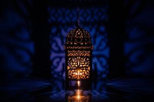 svart lykta med reflexion från blå bakgrund för de muslim fest av de helig månad av ramadan kareem. foto