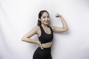 upphetsad asiatisk sportig kvinna bär en sportkläder som visar stark gest förbi lyft henne vapen och muskler leende stolt foto