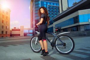 smal ung sporter kvinna på cykel foto