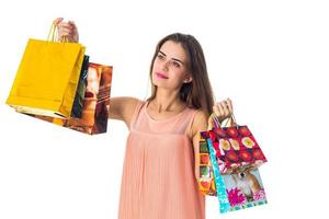 ung flicka Uppfostrad i de händer av stor färgad paket butiker isolerat på vit bakgrund foto