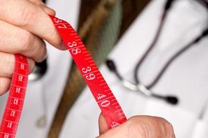 läkare med stetoskop innehav mätning tejp foto