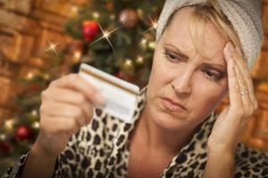 upprörd kvinna innehav kreditera kort i främre av jul träd foto