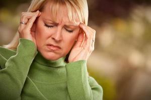 grimaserande kvinna lidande en huvudvärk foto