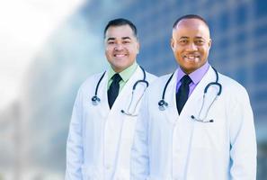 afrikansk amerikan och latinamerikan manlig doktorer utanför av sjukhus byggnad foto