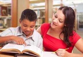 latinamerikan mor och son studerar i bibliotek foto