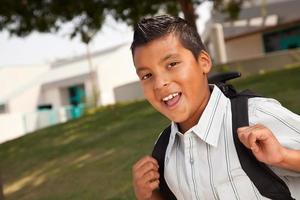 Lycklig ung latinamerikan pojke redo för skola foto